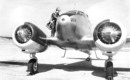 Pilot standing atop a Curtiss Wright AT 9A aircraft.