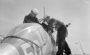 U.S. Navy sailors check the pilot seat of a Curtiss SNC 1 Falcon training plane.